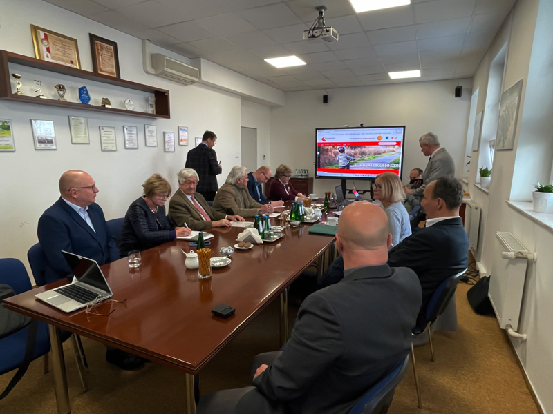 Grupa osób na zebraniu w sali konferencyjnej
